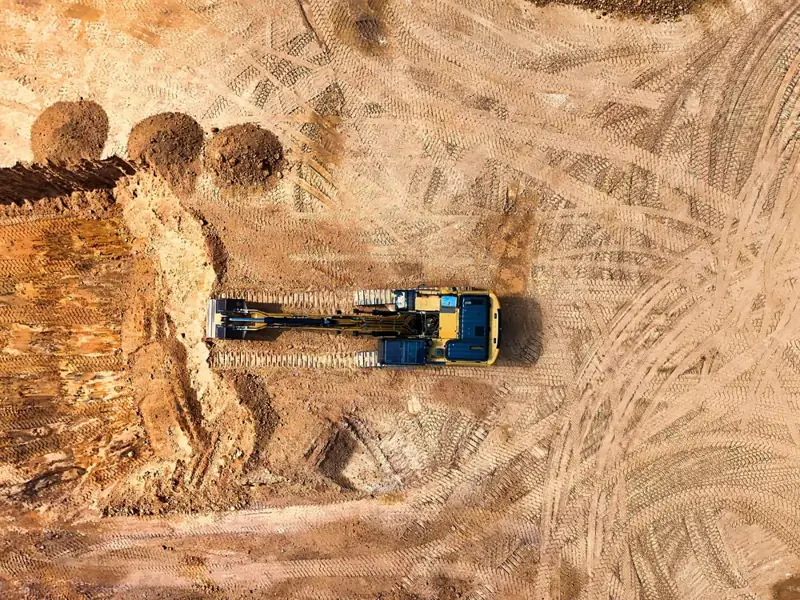 Overhead view of an excavator on a desert job site
