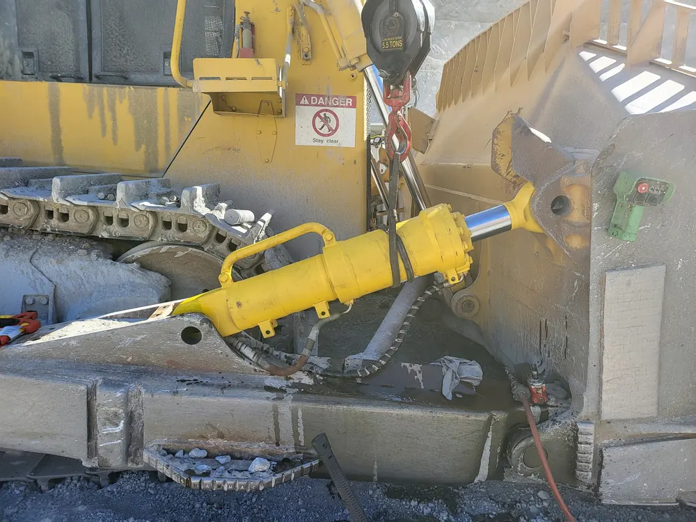 Hydraulic cylinder repair on a yellow heavy equipment machine