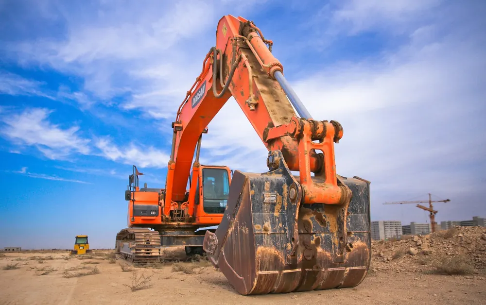 Orange excavator with bucket on a construction site