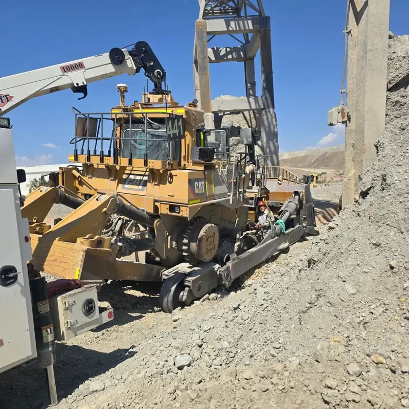Service truck crane lifting a component off a dozer