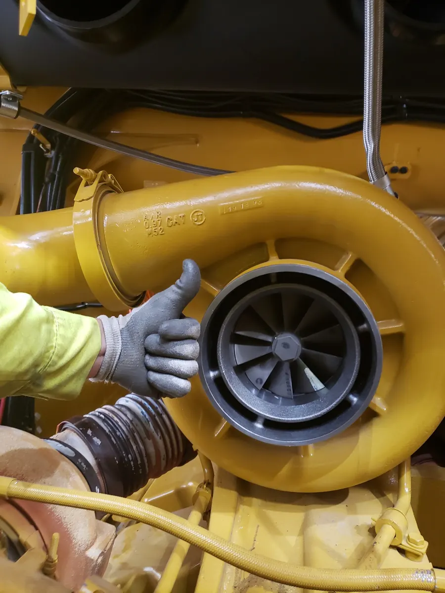 Technician holding a heavy equipment turbocharger